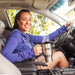 A Happy Woman In A Car Holding Wagan Tech 12V Deluxe Heated Mug
