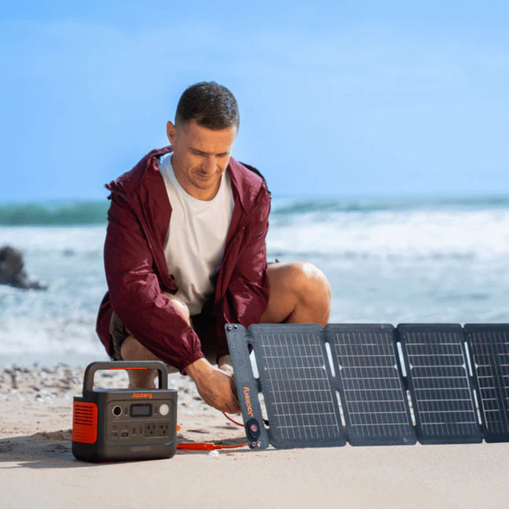 A man connecting the Jackery Explorer 300 v2 Portable Power Station to a solar panel