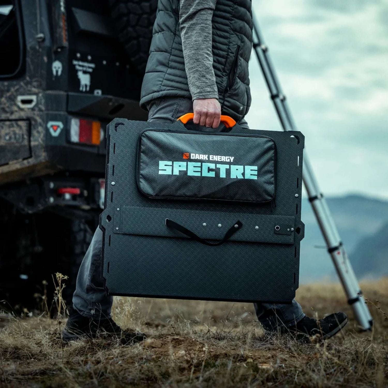A man holding a folded Dark Energy Spectre 200W Solar Panel 