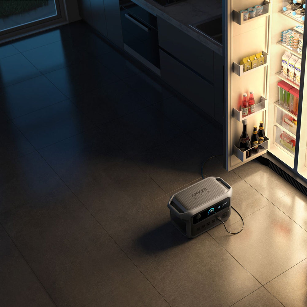 Anker SOLIX C2000 Gen 2 Portable Power Station on a kitchen floor with an open refrigerator in the background