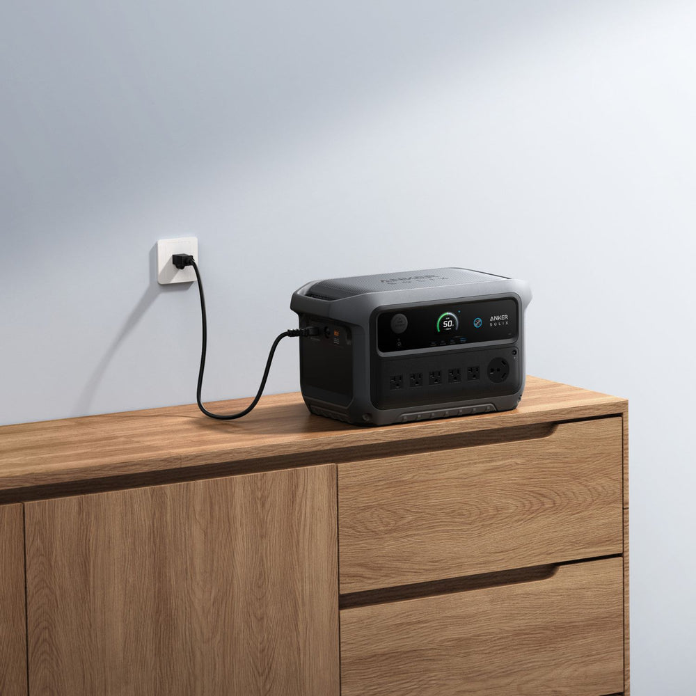 Anker SOLIX C2000 Gen 2 Portable Power Station on a wooden surface with a wall outlet in the background