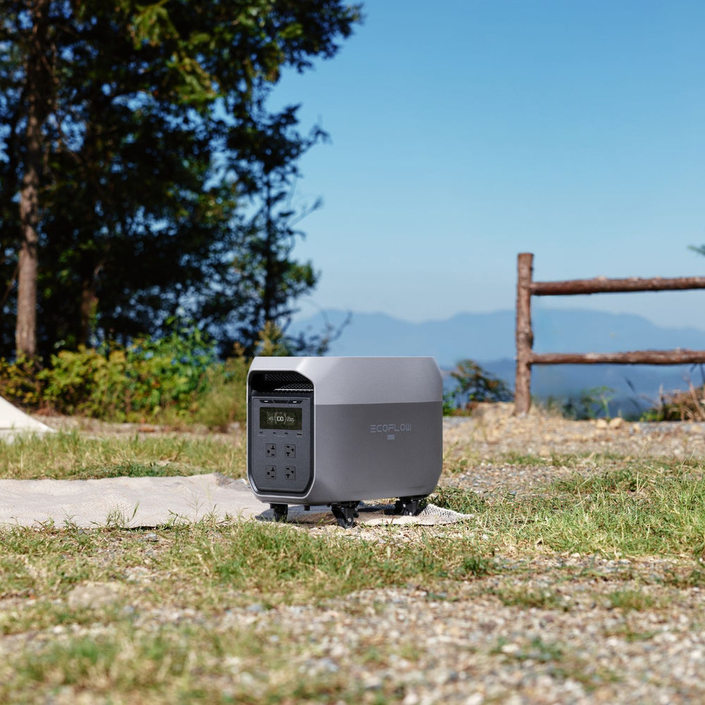 DELTA 3 Max Portable Power Station Black silver on a grassy area with trees and mountains in the background