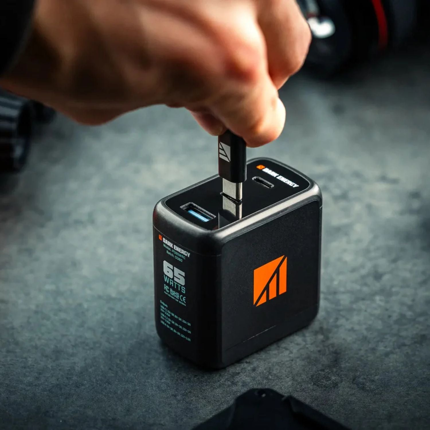 Dark Energy 65W AC Wall Adapter with USB-C cable charging a device.