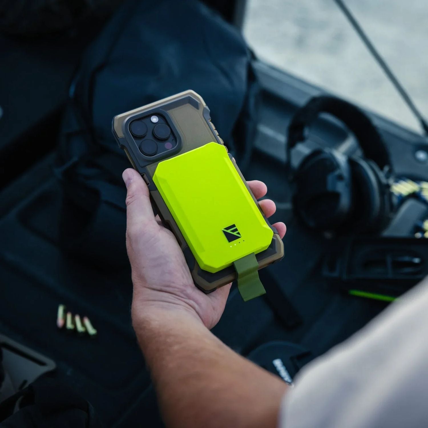 Dark Energy Poseidon Nano Power Bank - Green magnetically attached to a iphone held by a man.Dark Energy Poseidon Nano Power Bank - Green magnetically attached to a iphone held by a man.