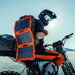 Dark Energy Spectre 18W Solar Panel - Orange at the back of a man riding his motorcycle 