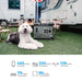 Dog lying on grass next to a OUKITEL P5000 Portable Power Station with an RV in the background