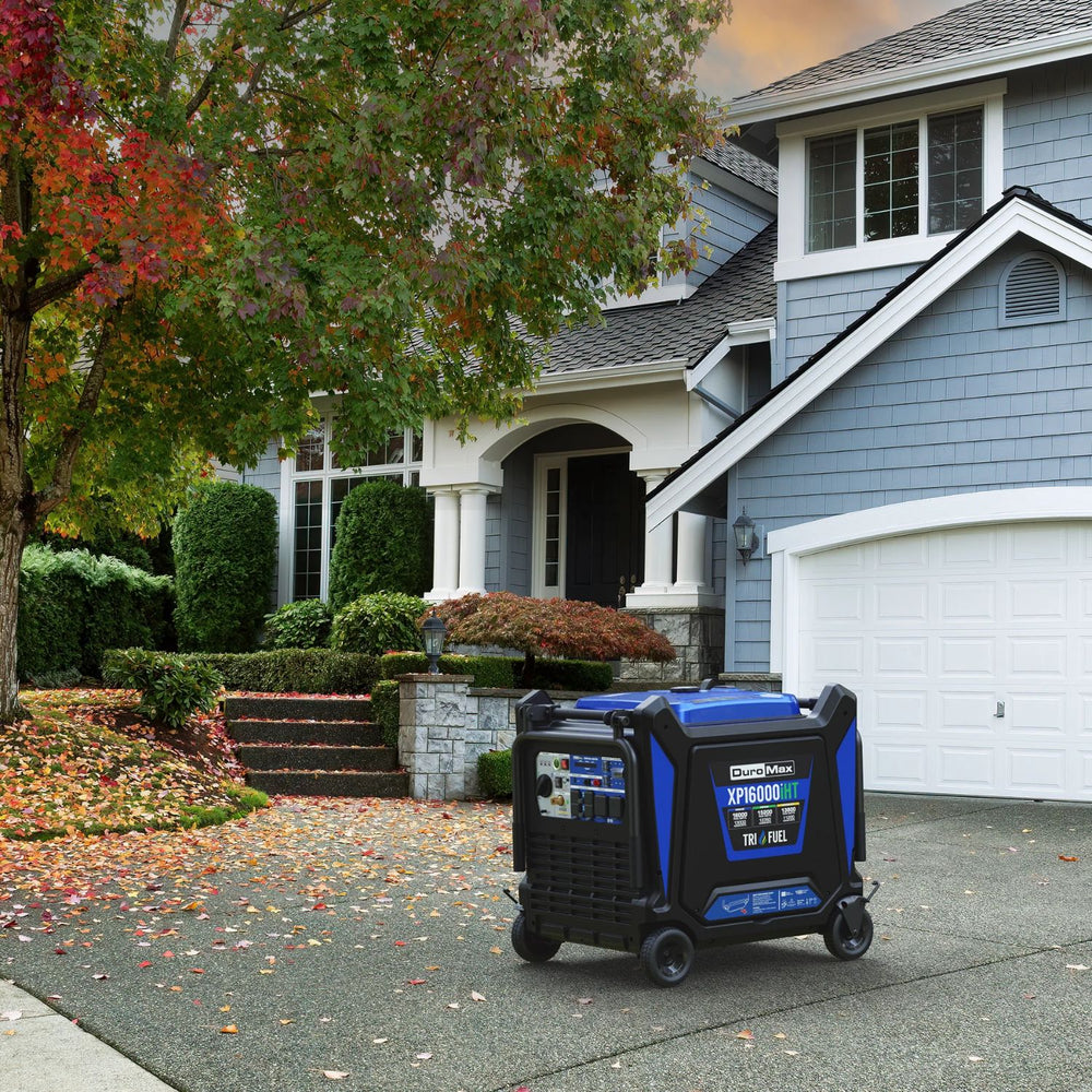 DuroMax XP16000iHT Tri-Fuel Generator on a driveway in front of a house with trees and shrubs.