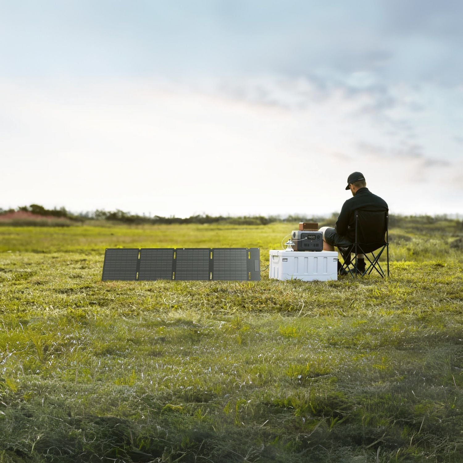 EcoFlow 45W Portable Solar Panel in use outdoors, connected to a power station with a man sitting beside it