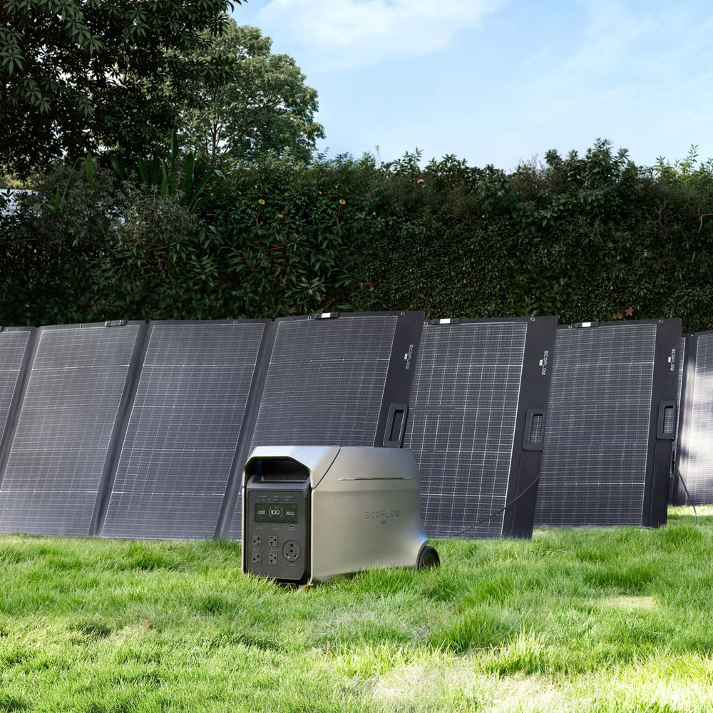 EcoFlow DELTA 3 Ultra Plus Portable Power Station in front of solar panels on a grassy area with trees in the background