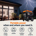 Generac GP15500EFI generator in front of a house with lightning in the background, emphasizing portable power solutions.