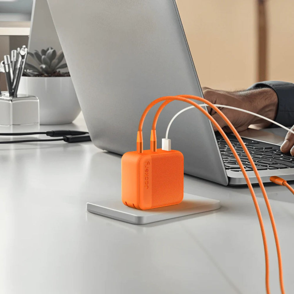 Jackery 102W GaN 3-Port Fast Charger hub connected to a laptop 