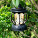 Jackery Camping Lantern with reflective interior hanging among green leaves