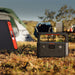 Jackery Explorer 600 v2 in a camping setting with tents in the background