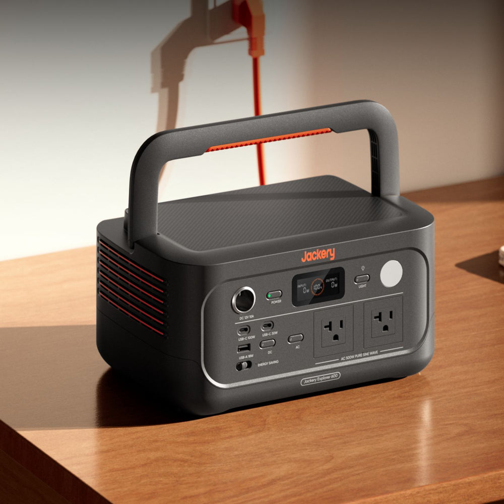 Jackery Explorer 600 v2 on a wooden surface with a blurred background