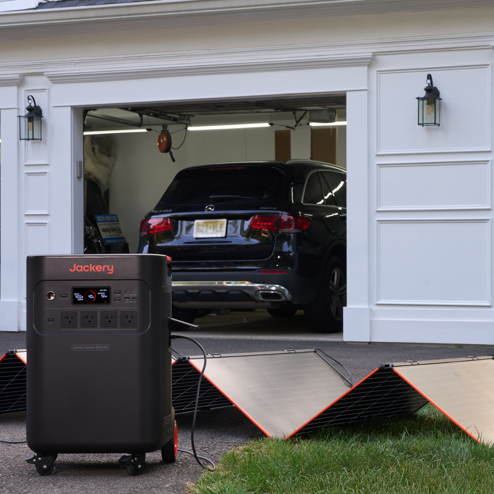 Jackery HomePower 3600 Plus Portable Power Station in front of a garage with a car inside