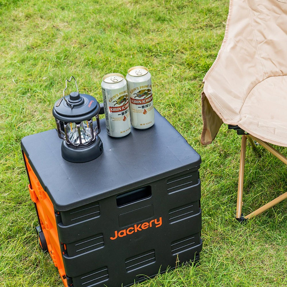 Jackery portable power station with a Jackery Camping Lantern and beer cans on grass