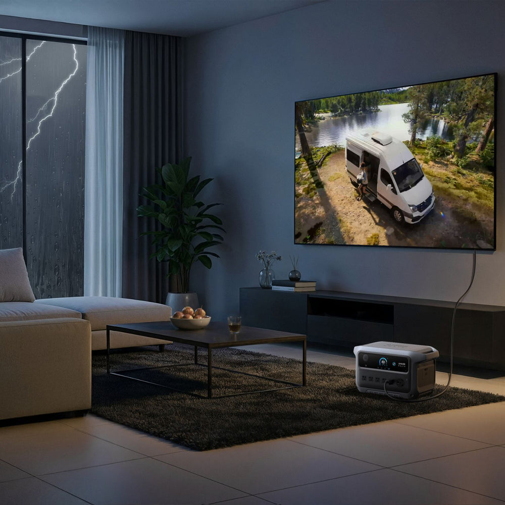 Living room with a TV displaying an RV on a screen, connected to a Anker SOLIX C2000 Gen 2 Portable Power Station
