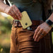 Man Putting the Dark Energy Poseidon Nano Power Bank - Desert Into His Pocket