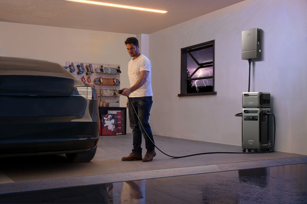 Man using the Anker SOLIX F3800 Plus Power Station to charge his car in the garage