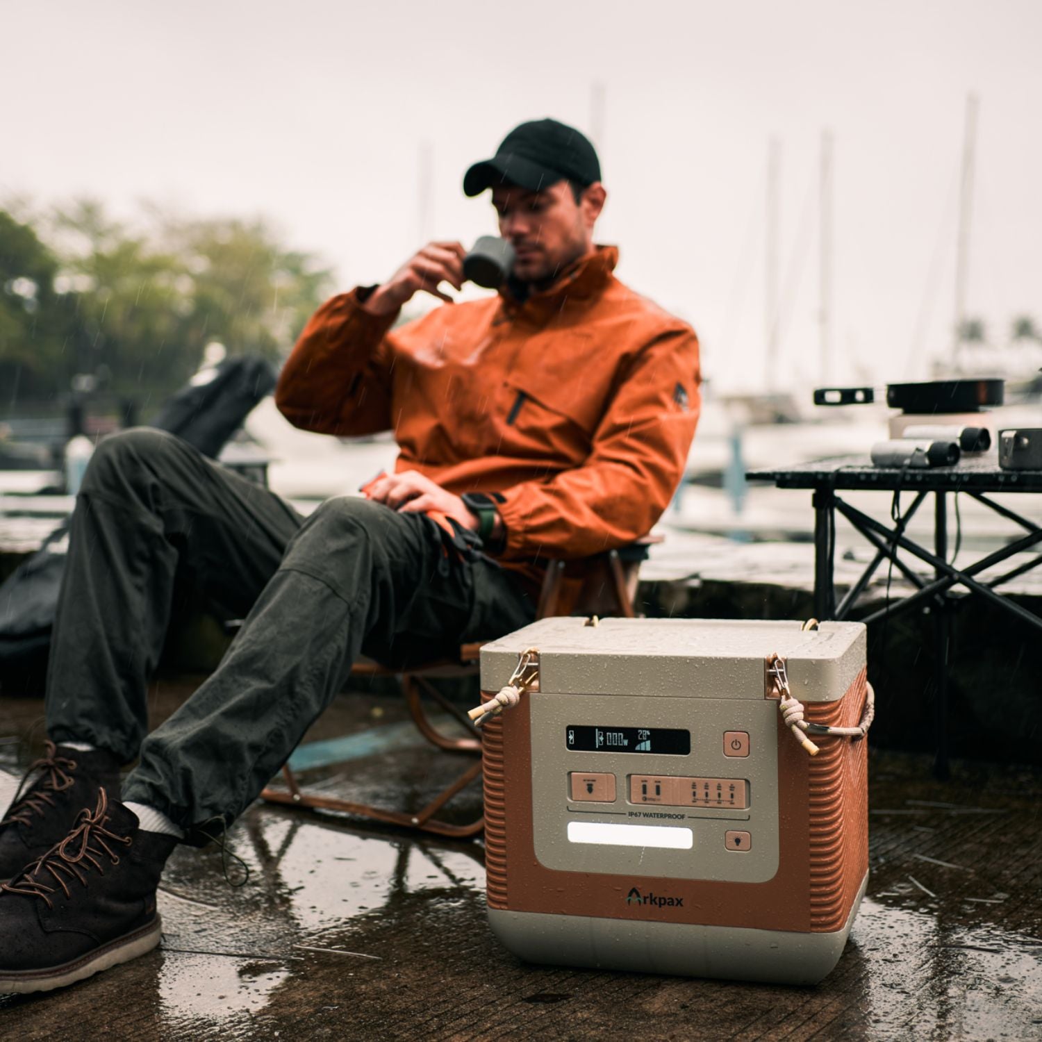 Man drinking coffee behind Arkpax Ark Portable Power Station on table