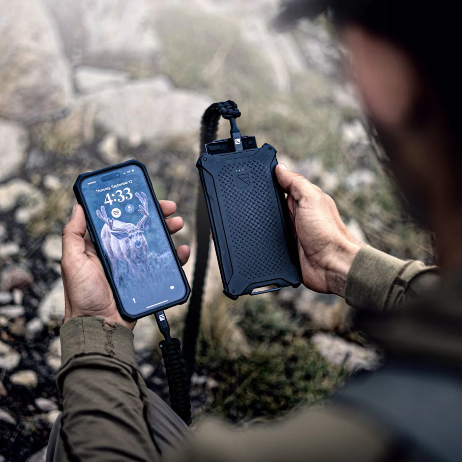 Man holding Dark Energy Poseidon Pro Power Bank - Black connected to a phone