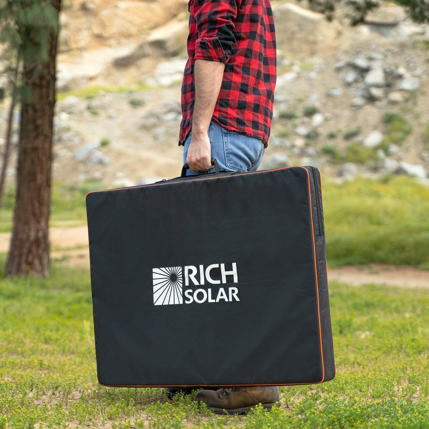 Man holding Rich Solar Mega 200W Portable Solar Panel Briefcase with cover