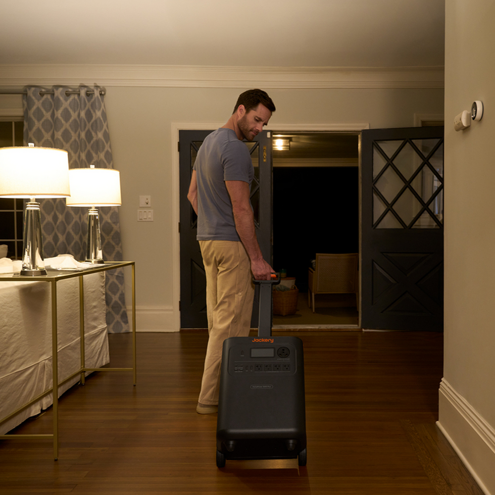 Man pushing a Jackery HomePower 3600 Plus Portable Power Station in a home setting