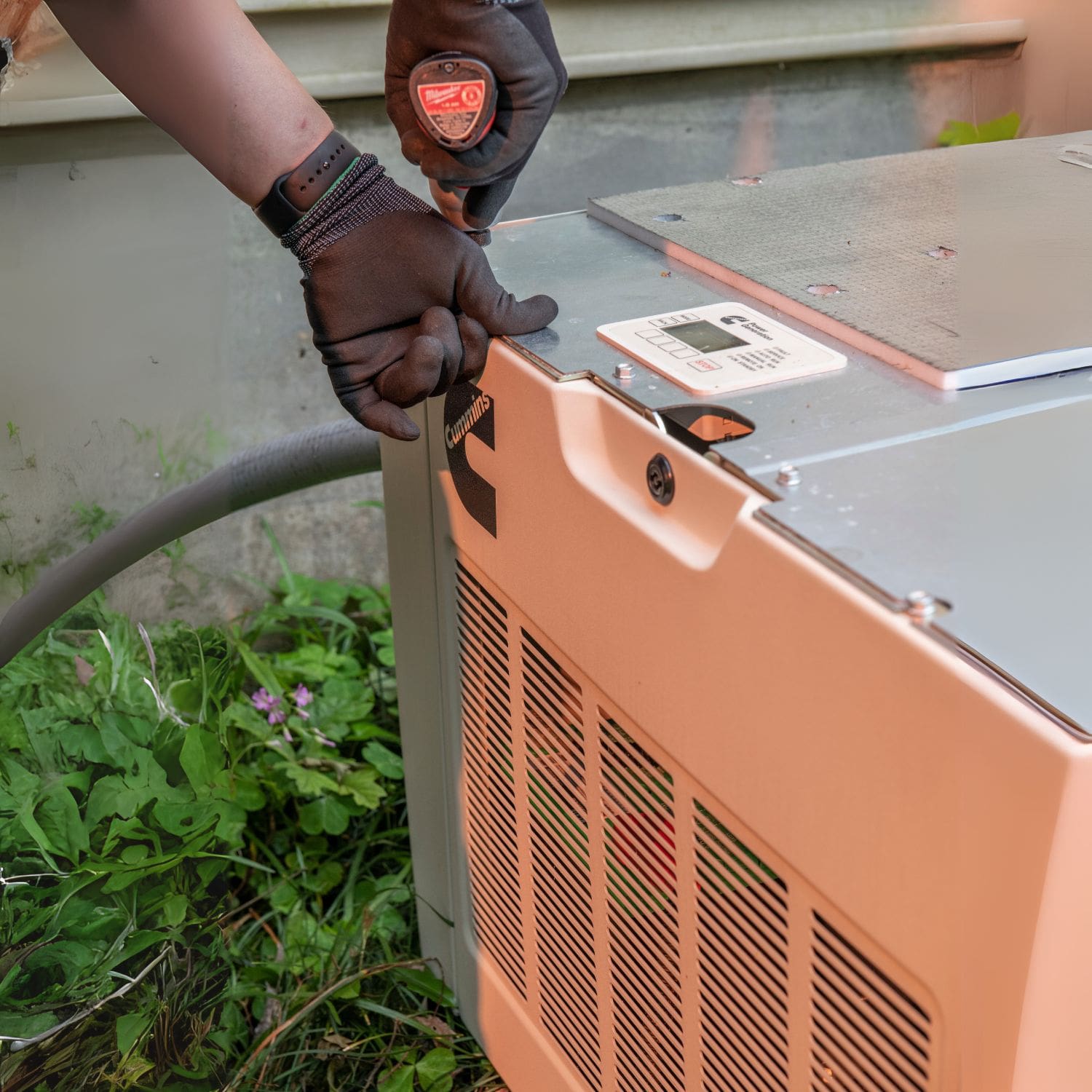 Man securing bolts on Cummins RS20A 20kW Home Standby Generator installation