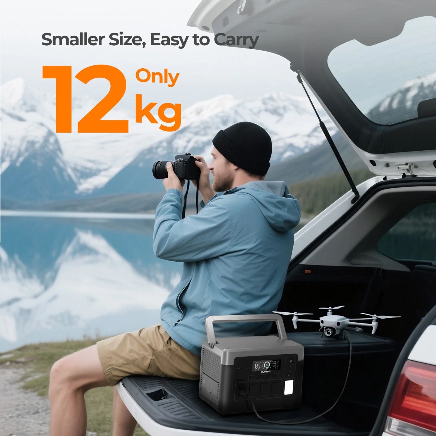 Man with camera and drone on car trunk with mountains in the background and a OUKITEL P1000 PLUS Portable Power Station 