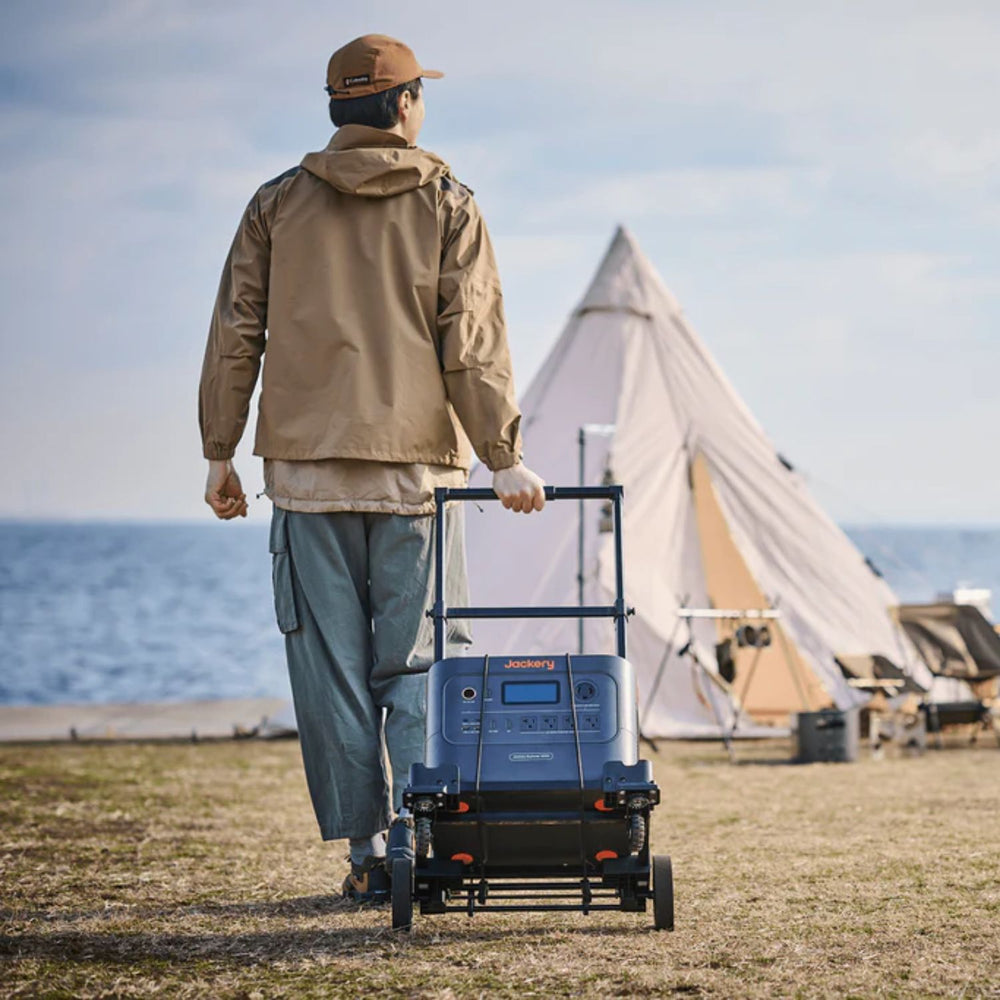 Person Jackery Power Station Trolley with a tent and ocean view in the background