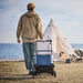 Person Jackery Power Station Trolley with a tent and ocean view in the background
