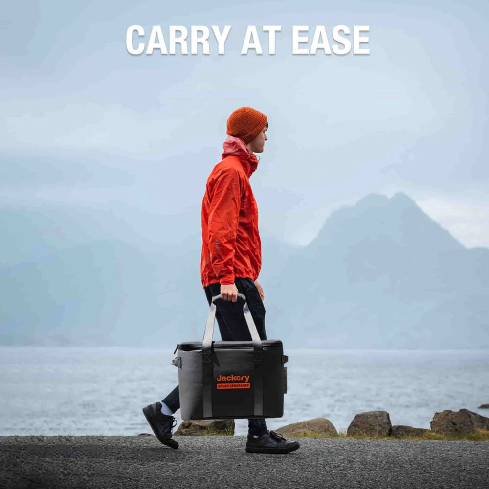 Person carrying a cooler with Jackery Upgraded Carrying Case (M) near a beach and mountains.
