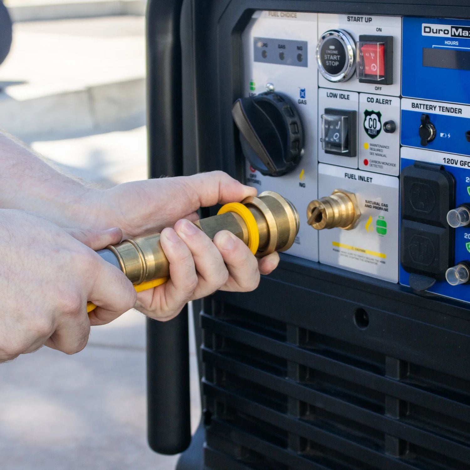 Person connecting a hose to a DuroMax XP16000iHT Tri-Fuel Generator 