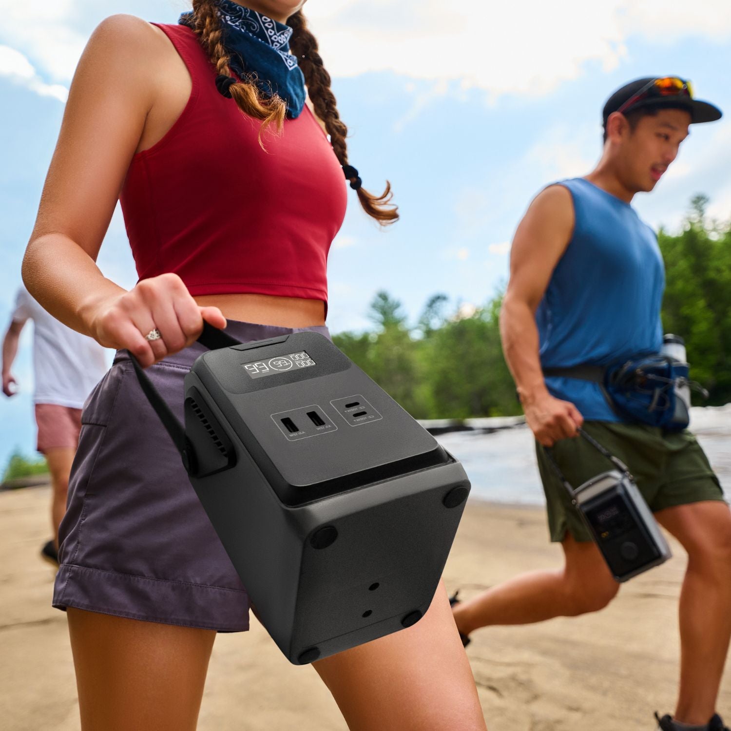 Person holding a EcoFlow TRAIL 200DC Portable Power Station with a scenic background of people walking by a lake.