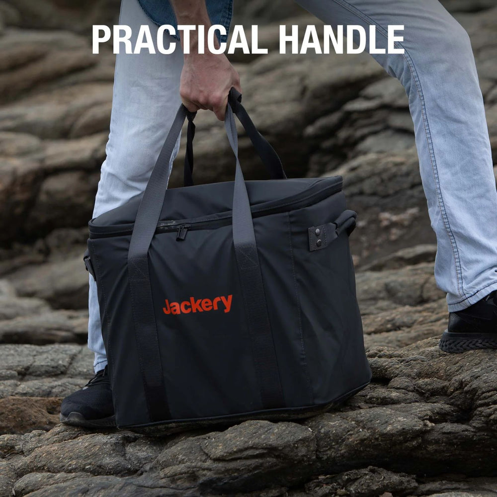 Person holding a Jackery Upgraded Carrying Case (L) on rocky terrain 