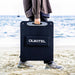 Person holding a OUKITEL 200W Portable Solar Panel on a beach.