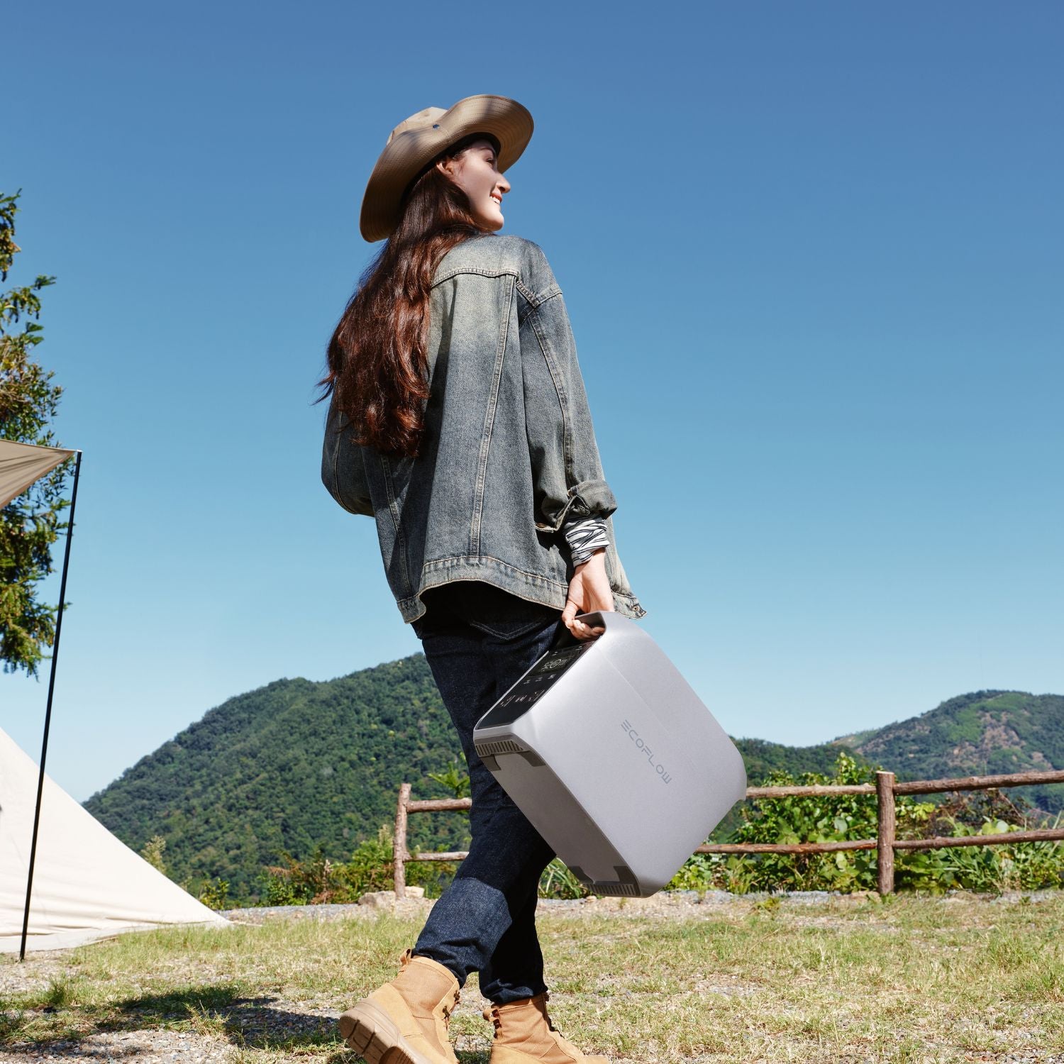 Person in outdoor setting with mountains and a tent, holding a EcoFlow DELTA 3 Classic Portable Power Station
