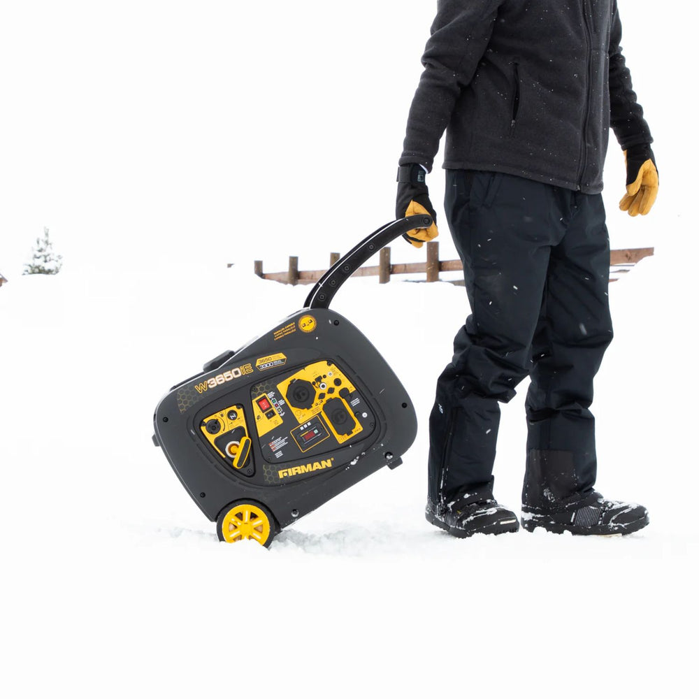 Person in winter clothing carrying a Firman W03382 Generator in the snow