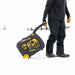 Person in winter clothing carrying a Firman W03382 Generator in the snow