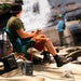 Person sitting on a chair by a waterfall using a EcoFlow TRAIL 300DC Portable Power Station