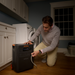 Person using a Jackery HomePower 3600 Plus Portable Power Station in a laundry room.
