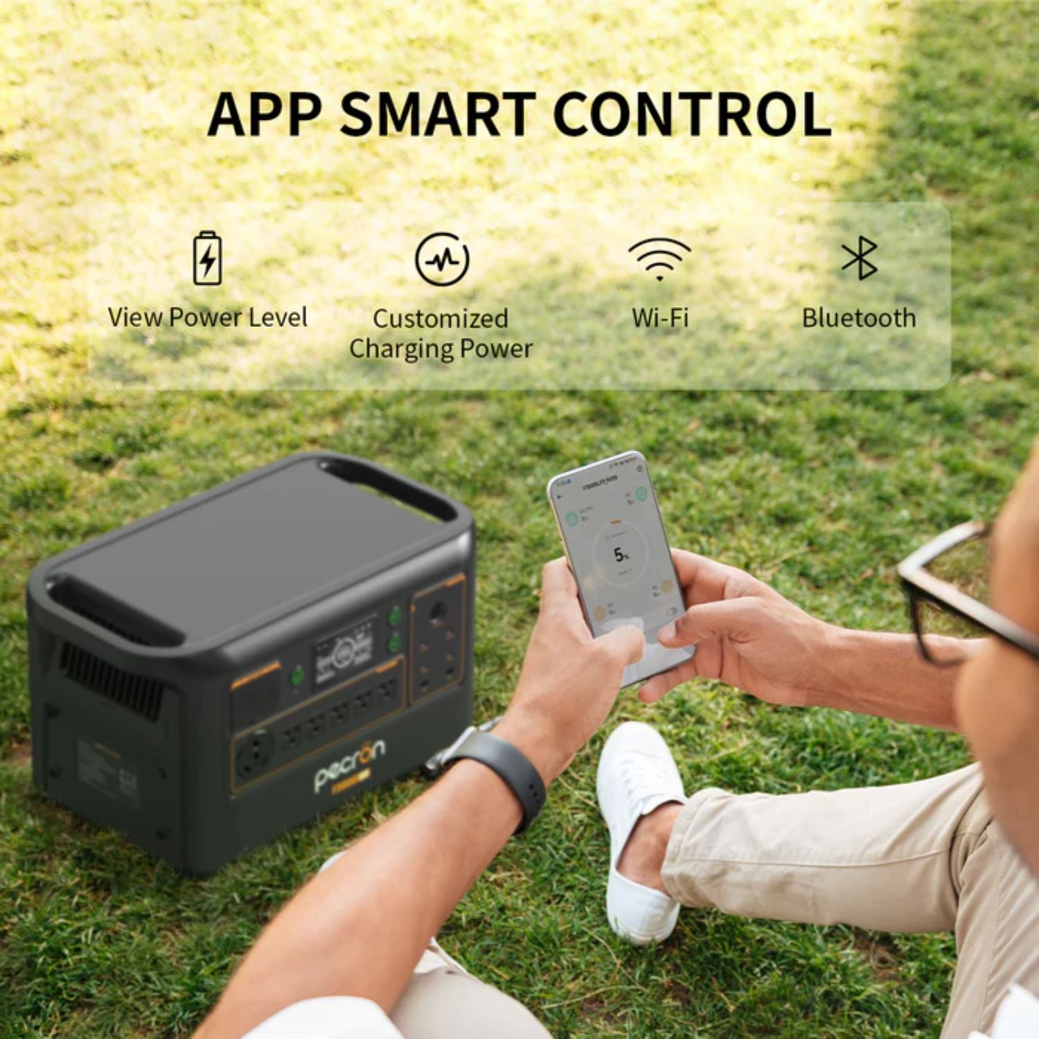 Person using a smartphone app to control a portable power station on grass