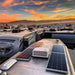 Solar panels on the roof of a recreational vehicle with a scenic sunset in the background.