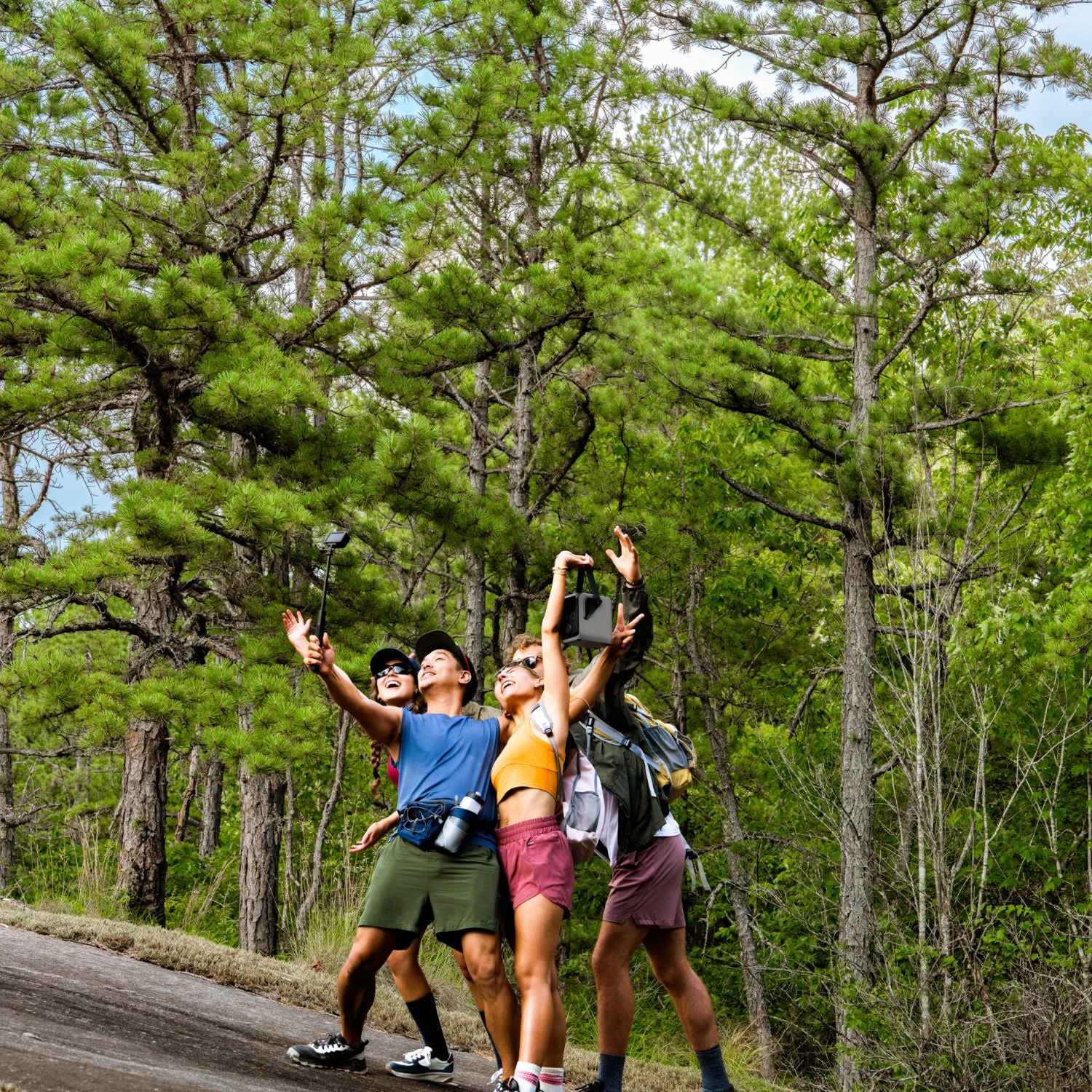 Three people taking a selfie in a forest one is holding an EcoFlow TRAIL 200DC Portable Power Station