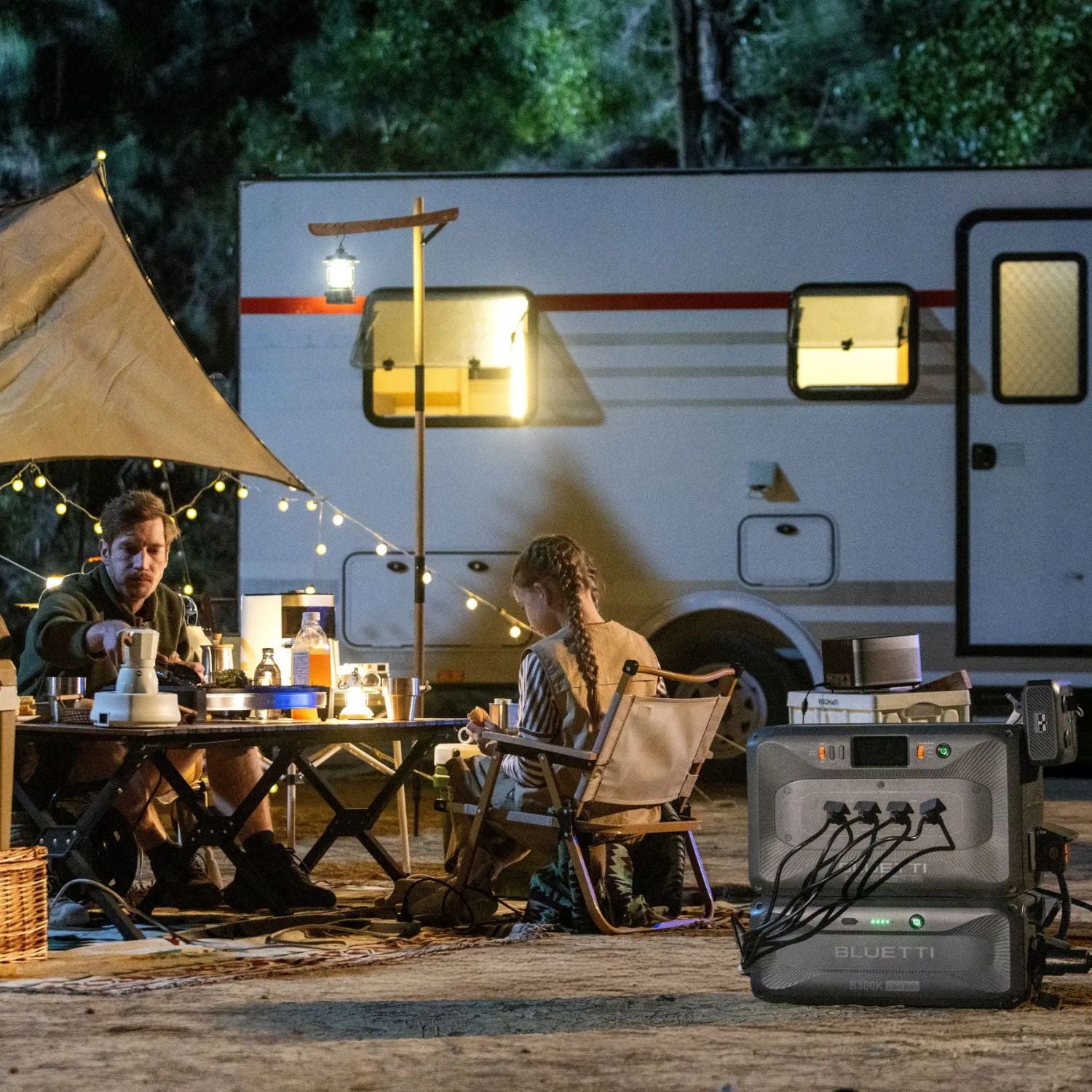 Two people camping outdoors with a BLUETTI Apex 300 Versatile Power Station in front of an RV.