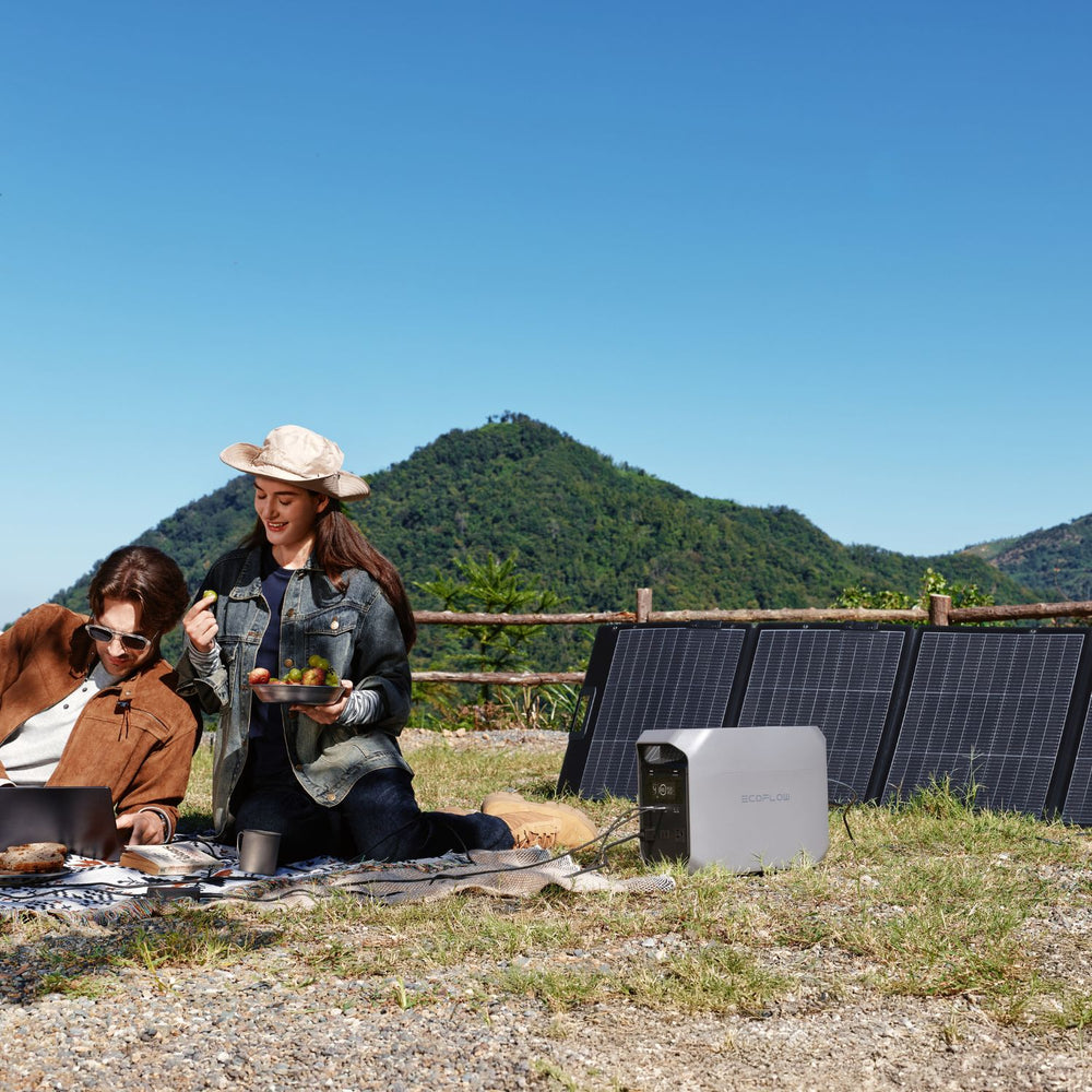 Two people having a picnic with solar panels connected to EcoFlow DELTA 3 Classic Portable Power Station 