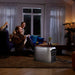 Two people sitting on a couch in a dimly lit room with a EcoFlow DELTA 3 Max Plus Portable Power Station on the floor.