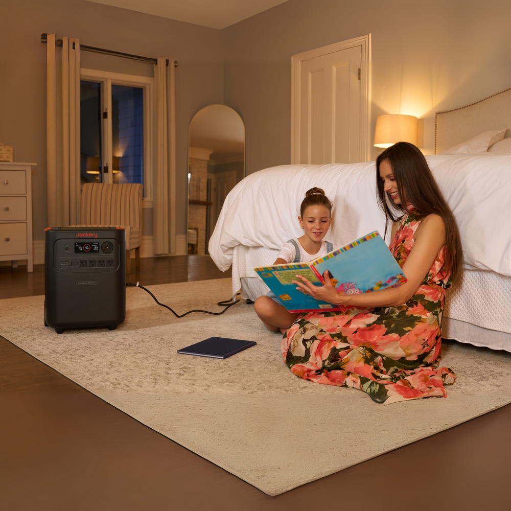 Woman and child reading a book in a bedroom with a Jackery HomePower 3600 Plus Portable Power Station