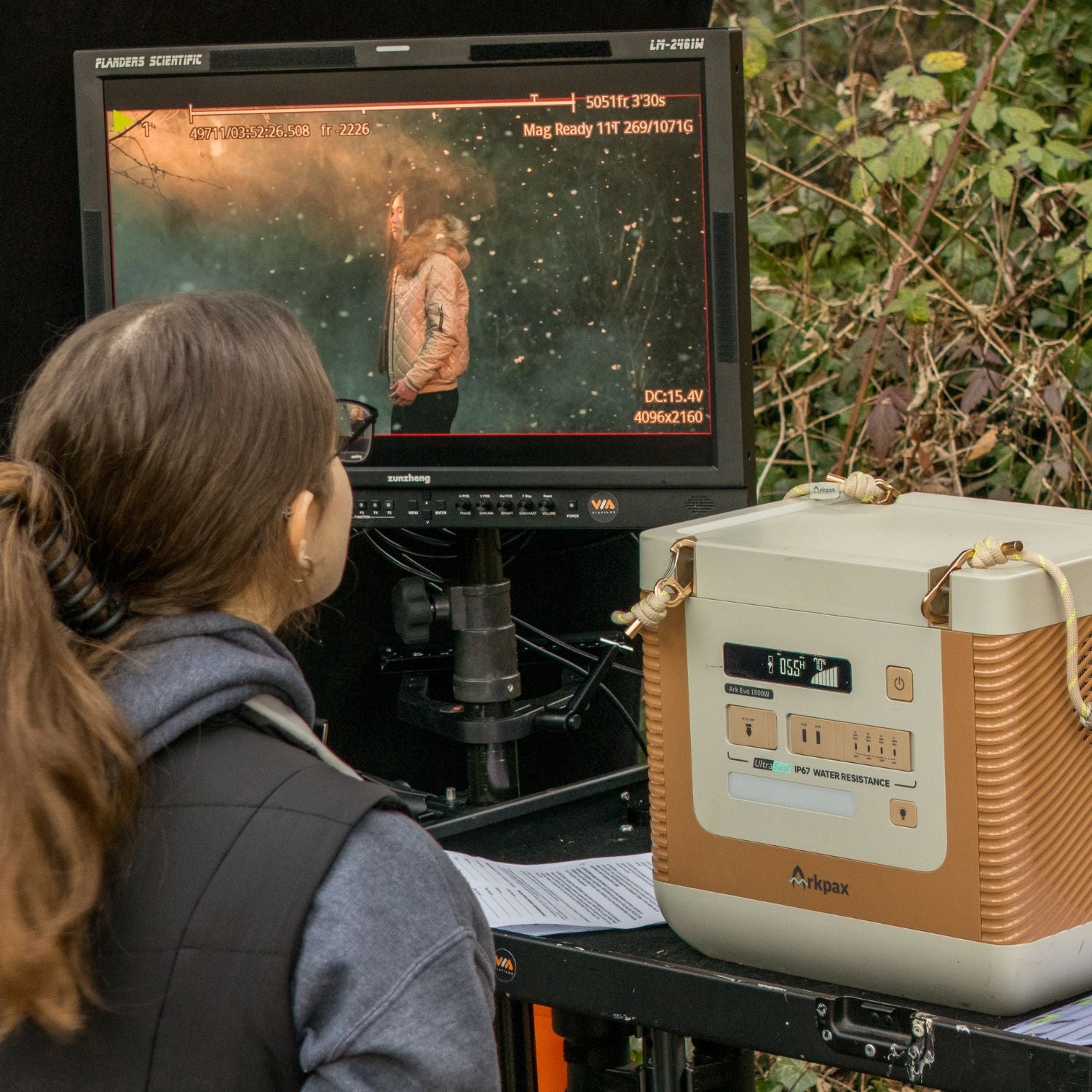 Woman using Arkpax Ark Evo Portable Power Station to power taping equipment