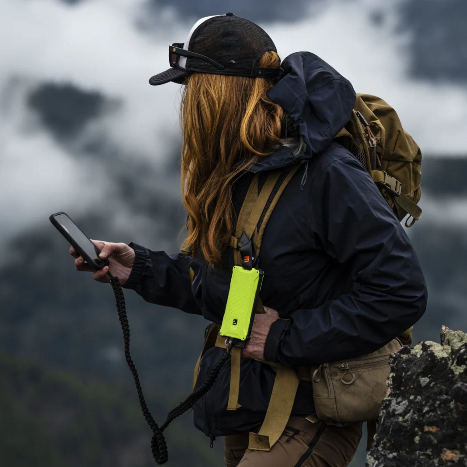Woman using it while her phone connected to Dark Energy Poseidon Pro Power Bank - Green
